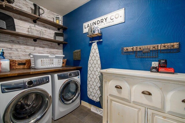 3265 Casey Trl, Oshkosh, WI 54904 - clothes washing area featuring washing machine and clothes dryer, cabinet space, and a textured wall