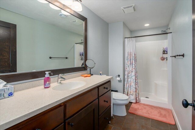 3265 Casey Trl, Oshkosh, WI 54904 - full bath featuring visible vents, toilet, vanity, a stall shower, and tile patterned flooring