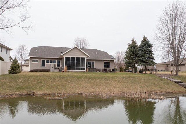 3265 Casey Trl, Oshkosh, WI 54904 - rear view of house with a sunroom, fence, a water view, a garage, and a lawn