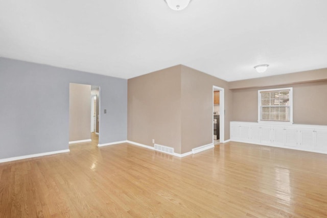unfurnished living room featuring baseboards, light wood-style flooring, and visible vents