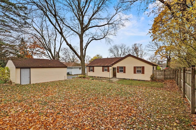 back of house with a fenced backyard and an outdoor structure