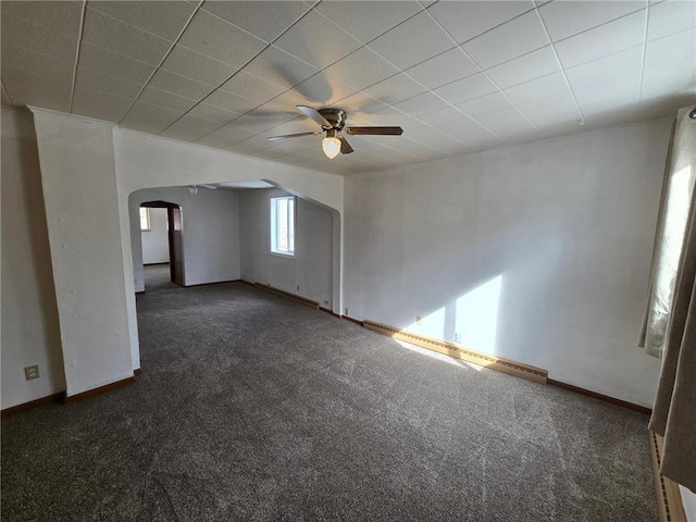 spare room with arched walkways, carpet, baseboards, and ceiling fan