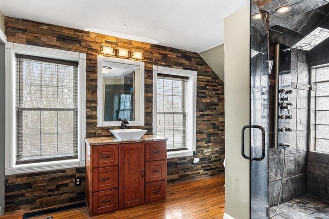 3304 Nicolet Dr, Green Bay, WI 54311 - bathroom featuring vaulted ceiling, a stall shower, vanity, and wood-type flooring
