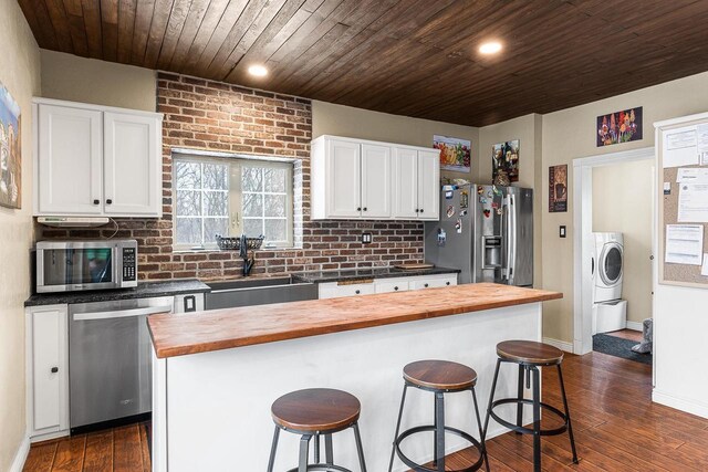 3304 Nicolet Dr, Green Bay, WI 54311 - kitchen featuring wooden counters, stainless steel appliances, a sink, a kitchen breakfast bar, and washer / dryer