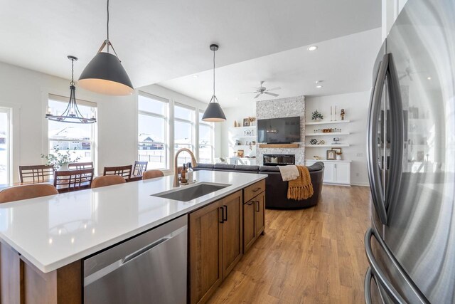 150551 Lavender Ln, Wausau, WI 54401 - kitchen with a sink, a ceiling fan, light wood finished floors, appliances with stainless steel finishes, and a stone fireplace