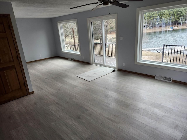 N9148 Sandy Lake Rd, Neshkoro, WI 54960 - empty room with a ceiling fan, wood finished floors, a textured ceiling, baseboards, and visible vents