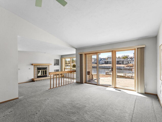 535 E Vine Ct, Sturgeon Bay, WI 54235 - unfurnished living room featuring a fireplace, carpet floors, lofted ceiling, and baseboards