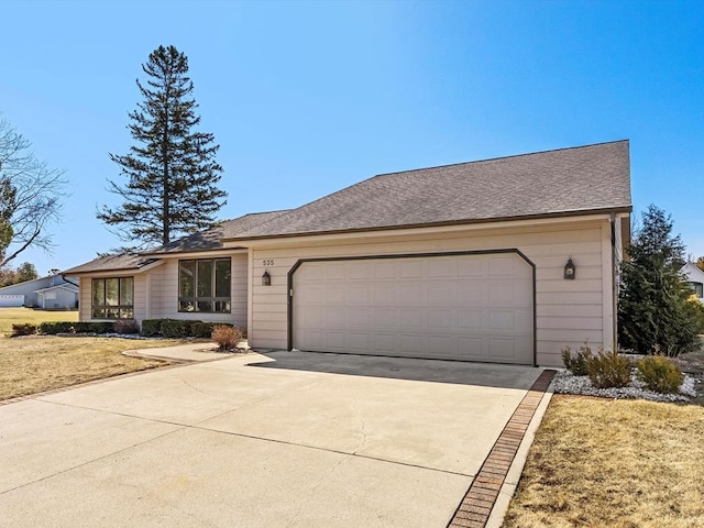 535 E Vine Ct, Sturgeon Bay, WI 54235 - view of front of home with concrete driveway, a front lawn, and an attached garage