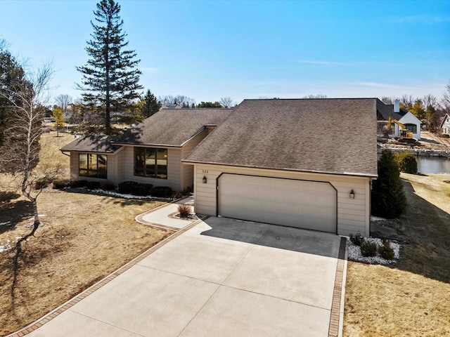 535 E Vine Ct, Sturgeon Bay, WI 54235 - view of front of house with a shingled roof, a garage, and concrete driveway