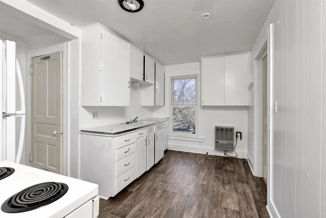 kitchen featuring white appliances, white cabinets, a sink, baseboards, and dark wood-style floors