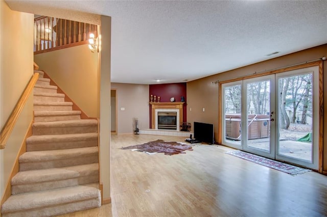 4330 S Pointe Ct, Eau Claire, WI 54701 - unfurnished living room with a tiled fireplace, visible vents, wood finished floors, and a textured ceiling