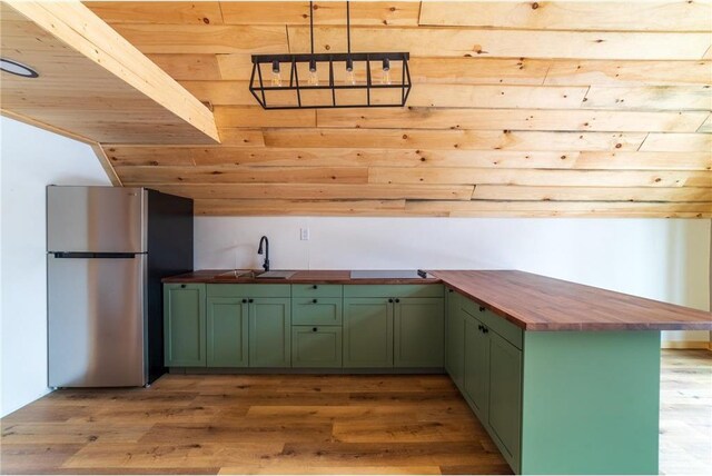 61128 Fleming Loop, Askov, MN 55704 - kitchen featuring a sink, freestanding refrigerator, green cabinets, wooden counters, and light wood-style floors