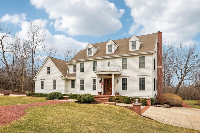 S51W29202 Ridgefield Rd, Waukesha, WI 53189 - view of front facade with a chimney, a front lawn, a shingled roof, and a balcony