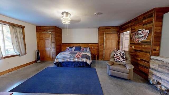 26350 Drake Ln, Cazenovia, WI 53924 - bedroom with baseboards, wooden walls, and concrete floors