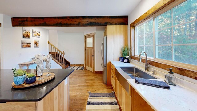 26350 Drake Ln, Cazenovia, WI 53924 - kitchen featuring baseboards, a sink, beam ceiling, light wood-style floors, and freestanding refrigerator