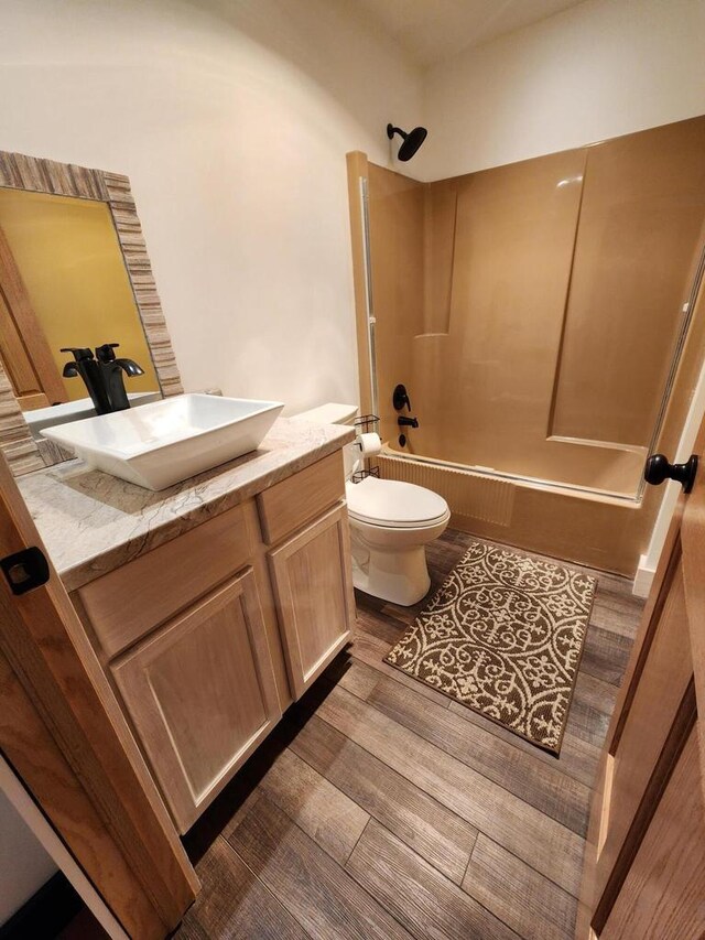26350 Drake Ln, Cazenovia, WI 53924 - bathroom featuring toilet, wood finished floors, vanity, and shower / bathtub combination
