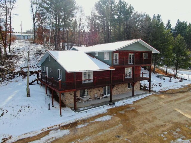 26350 Drake Ln, Cazenovia, WI 53924 - view of front of house with stone siding, a deck, and a patio area