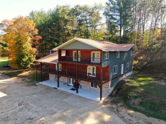 26350 Drake Ln, Cazenovia, WI 53924 - view of front of home with metal roof, stone siding, a patio, and french doors