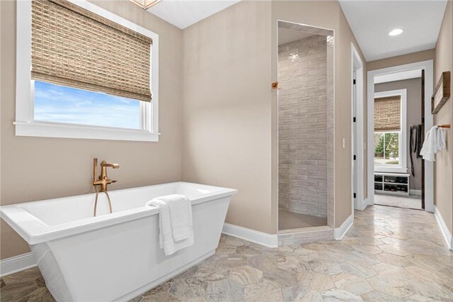 438 Highland Vw, Houlton, WI 54082 - bathroom with a freestanding bath, a shower stall, stone finish floor, and baseboards