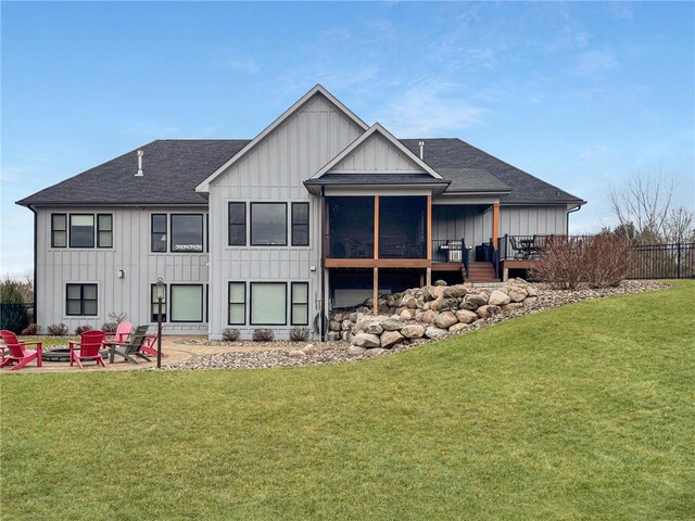 438 Highland Vw, Houlton, WI 54082 - rear view of house featuring a lawn, an outdoor fire pit, board and batten siding, and roof with shingles