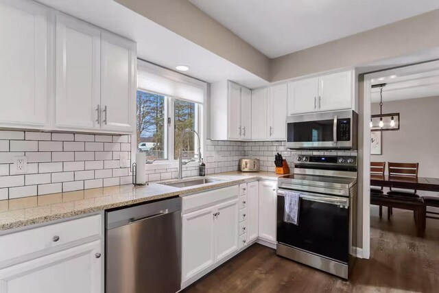 1800 Miller Rd, Lake Geneva, WI 53147 - kitchen with white cabinets, stainless steel appliances, dark wood-type flooring, a sink, and backsplash