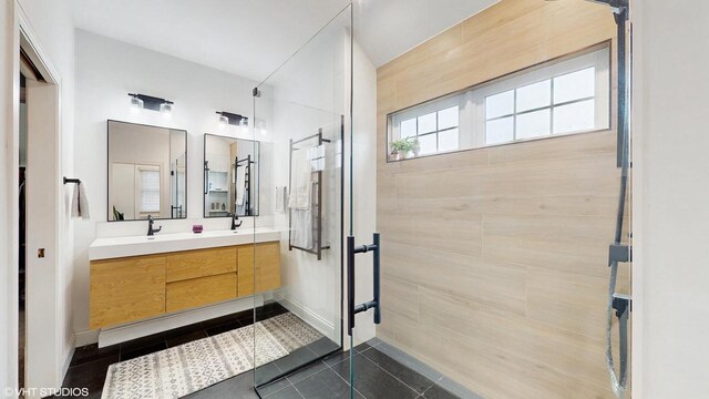 425 Maple Ln, Williams Bay, WI 53191 - bathroom featuring baseboards, double vanity, tile patterned floors, a sink, and a stall shower