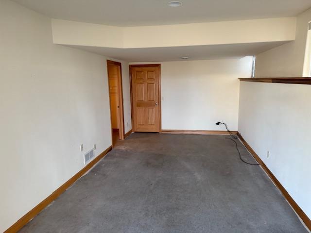 2026 Stonehaven Dr, Sun Prairie, WI 53590 - below grade area with baseboards, visible vents, and dark colored carpet