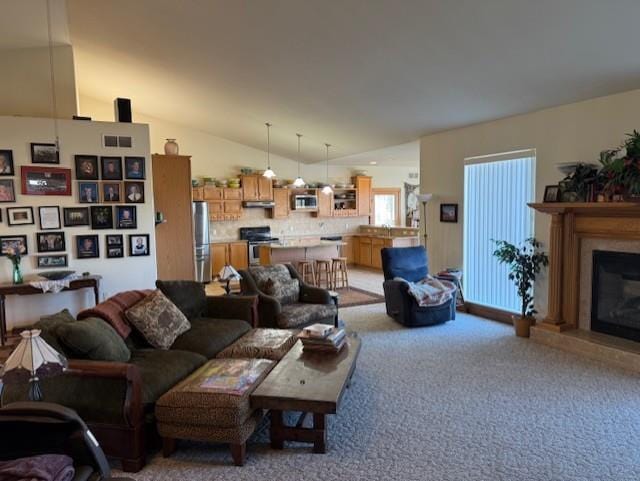 2026 Stonehaven Dr, Sun Prairie, WI 53590 - living area with light carpet, lofted ceiling, and a glass covered fireplace
