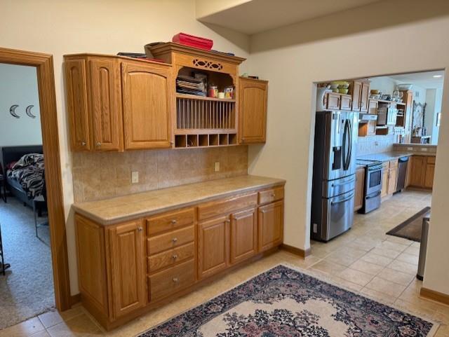 2026 Stonehaven Dr, Sun Prairie, WI 53590 - kitchen featuring stainless steel appliances, open shelves, light tile patterned floors, light countertops, and backsplash