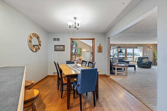 W1335 N Blue Spring Lake Dr, Palmyra, WI 53156 - dining room with baseboards, visible vents, a chandelier, and wood finished floors