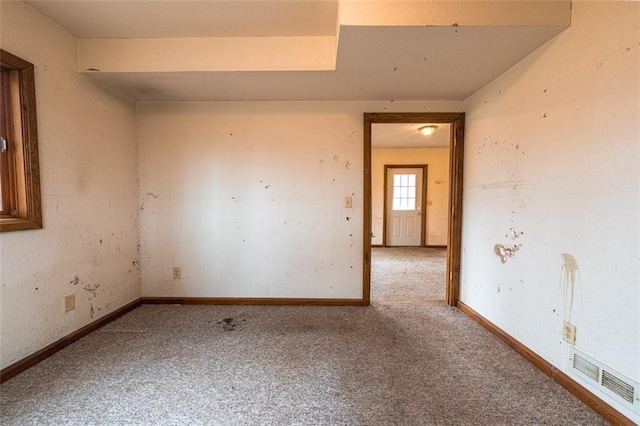 carpeted spare room with baseboards and visible vents