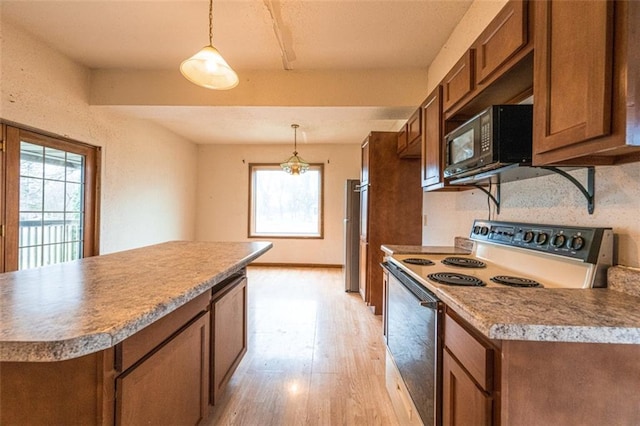 kitchen with black microwave, hanging light fixtures, white range with electric stovetop, light wood-type flooring, and brown cabinetry