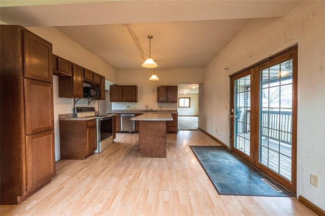 kitchen with a kitchen island, light wood finished floors, black microwave, stainless steel dishwasher, and range with electric stovetop