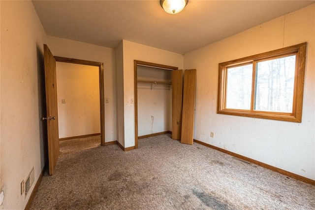 unfurnished bedroom with carpet floors, baseboards, a closet, and visible vents
