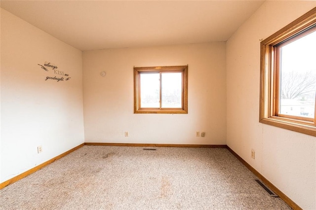carpeted empty room with baseboards and visible vents