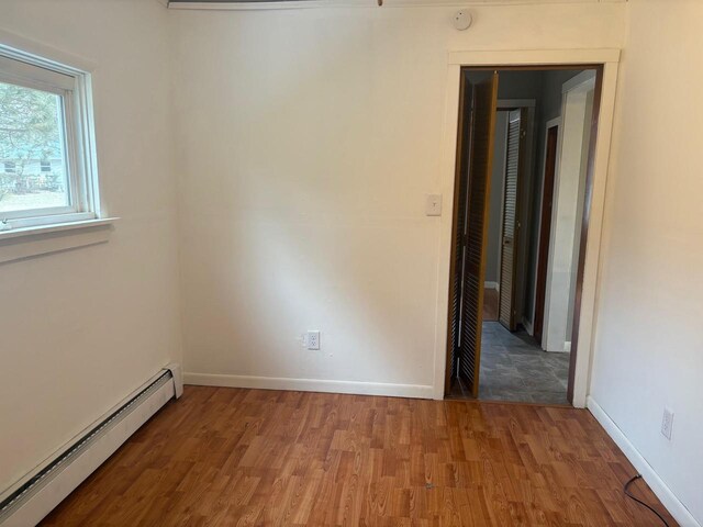 1006 Lulu Ave, Crivitz, WI 54114 - unfurnished room featuring a baseboard radiator, baseboards, and wood finished floors