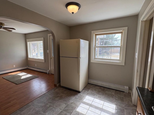 1006 Lulu Ave, Crivitz, WI 54114 - kitchen with freestanding refrigerator, a wealth of natural light, arched walkways, and baseboard heating