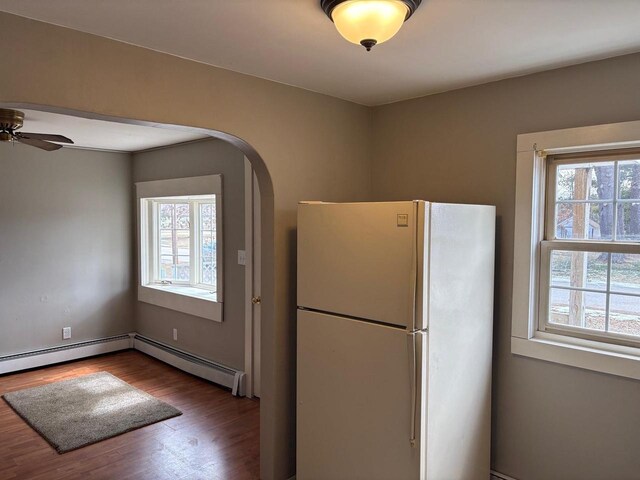 1006 Lulu Ave, Crivitz, WI 54114 - kitchen featuring a baseboard radiator, ceiling fan, wood finished floors, arched walkways, and freestanding refrigerator