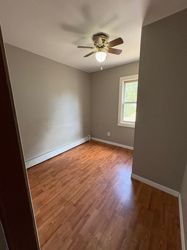 1006 Lulu Ave, Crivitz, WI 54114 - spare room featuring baseboards, baseboard heating, wood finished floors, and a ceiling fan