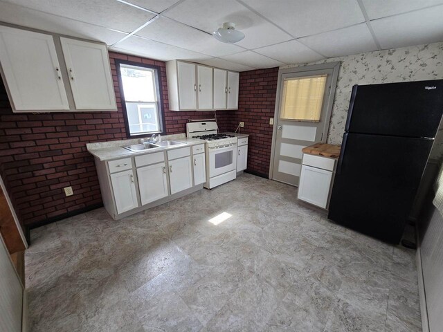 N10444 N Horseshoe Rd, Tomahawk, WI 54487 - kitchen featuring white gas stove, a sink, a paneled ceiling, and freestanding refrigerator