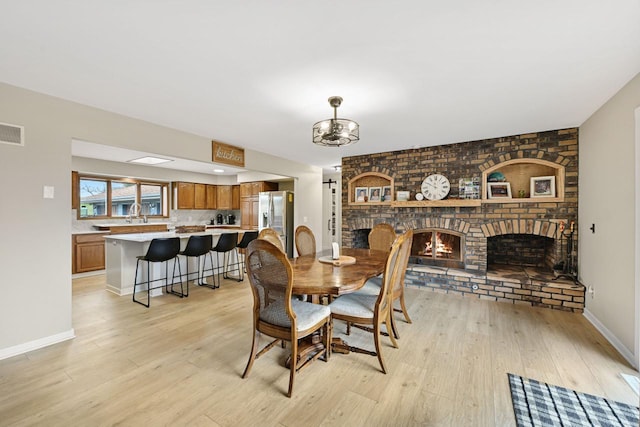 W590 Kearney Rd, Burlington, WI 53105 - dining room with visible vents, light wood-style flooring, a notable chandelier, and a fireplace
