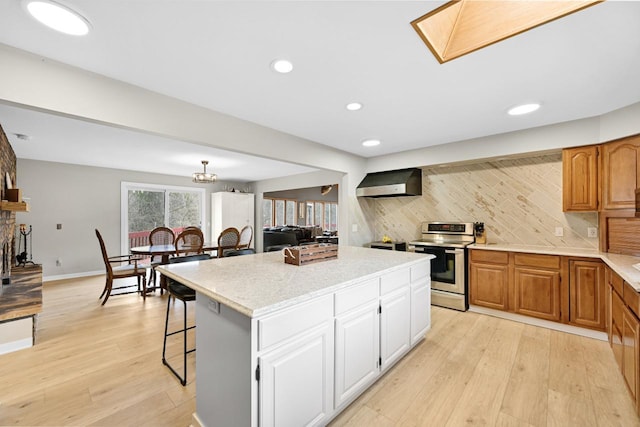 W590 Kearney Rd, Burlington, WI 53105 - kitchen with light wood-style floors, wall chimney exhaust hood, stainless steel electric range oven, a center island, and decorative backsplash