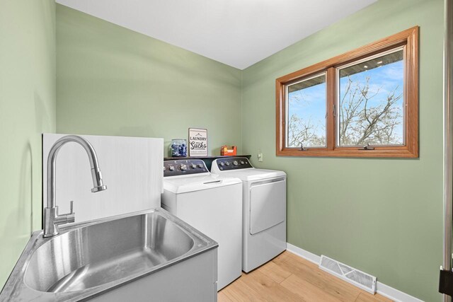 W590 Kearney Rd, Burlington, WI 53105 - laundry room with visible vents, independent washer and dryer, laundry area, light wood finished floors, and a sink