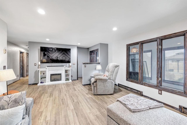 3237 Mill Rd, Greenleaf, WI 54126 - living room with a fireplace with raised hearth, a baseboard radiator, recessed lighting, and light wood finished floors
