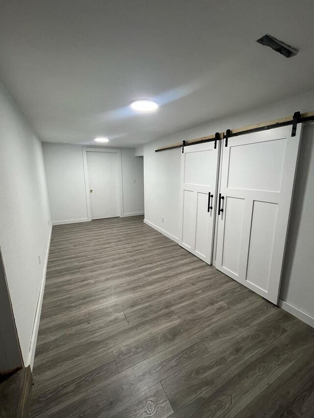 25290 Foothill Ave, Tomah, WI 54660 - basement featuring dark wood-style floors, a barn door, and baseboards