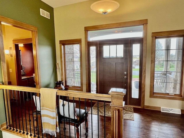 foyer entrance with wood-type flooring, visible vents, and a wealth of natural light