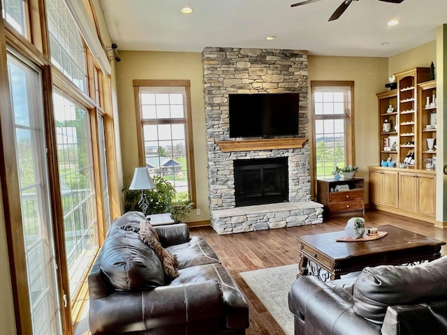 living room featuring recessed lighting, wood finished floors, baseboards, a fireplace, and ceiling fan