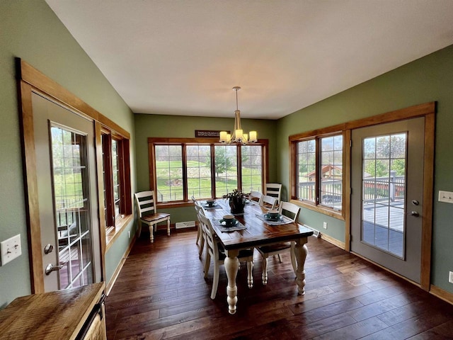 dining area featuring a chandelier, dark wood finished floors, a wealth of natural light, and baseboards