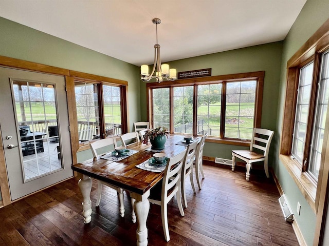 dining space with baseboards, visible vents, a chandelier, and dark wood finished floors