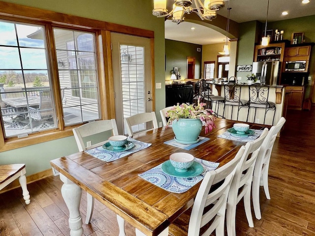 dining area featuring a chandelier, wood finished floors, baseboards, and recessed lighting